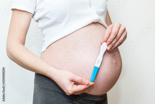 Positive pregnancy test and pregnant belly, ninth month, fertility