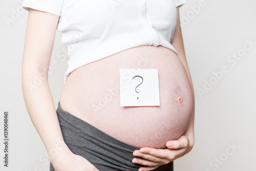 card with a question mark on a pregnant belly, baby's gender