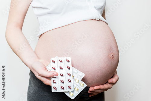 pregnancy belly, pregnant woman and a set of pregnancy vitamins