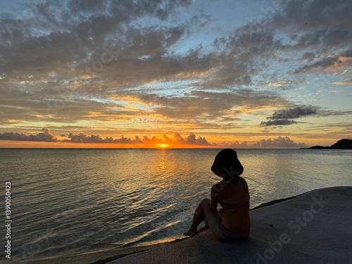 Фотография Woman watching sunset over ocean