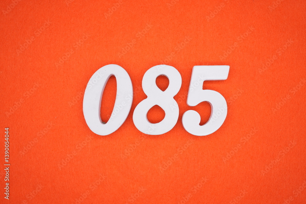 The numbers are made of white painted wood placed on an orange paper background. The numbers are made of white painted wood placed on an orange paper background.