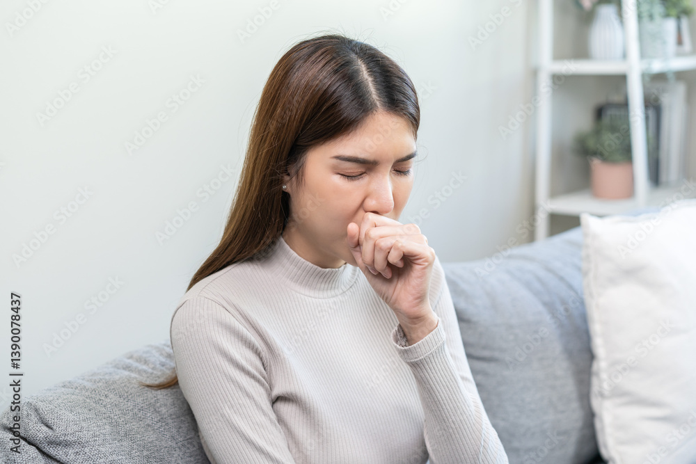 Unhealthy sickness asian young woman, girl unwell with coughing, have cold, sore throat on sofa, couch at home, suffering with symptom cough feeling bad. Health care of Coronavirus, covid-19 concept. Unhealthy sickness asian young woman, girl unwell with coughing, have cold, sore throat on sofa, couch at home, suffering with symptom cough feeling bad. Health care of Coronavirus, covid-19 concept.