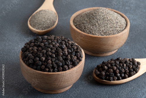 Ground black pepper with grains of black pepper on gray background

