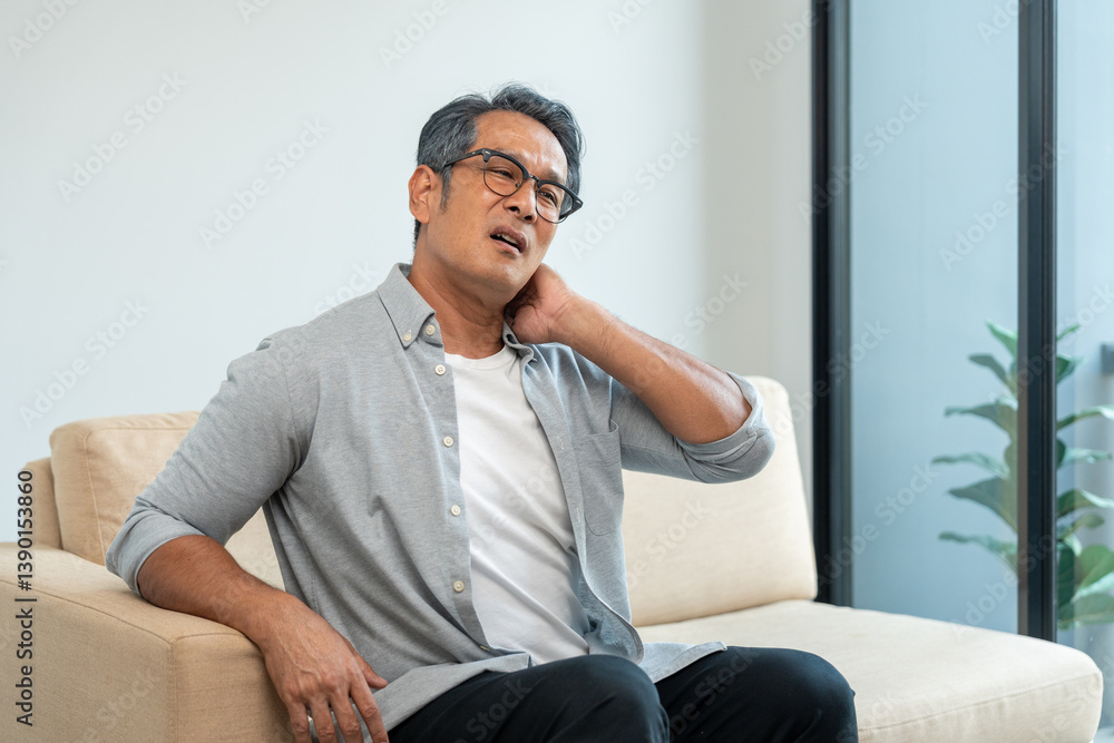 Old man senior has problem with structural posture He had neck and shoulder pain. Mature Massaged his neck and shoulders for relief. reduce muscle tension. Sitting on sofa couch in living room Old man senior has problem with structural posture He had neck and shoulder pain. Mature Massaged his neck and shoulders for relief. reduce muscle tension. Sitting on sofa couch in living room