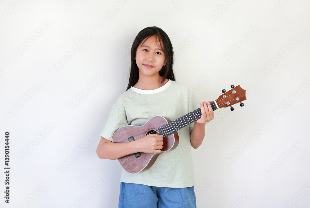 Portrait of Asian girl child playing ukulele isolated on white studio background. Portrait of Asian girl child playing ukulele isolated on white studio background.