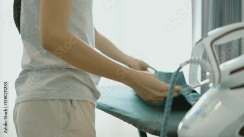 A person engaged in ironing clothes, demonstrating the importance of neatness and attention to detail. This everyday activity highlights the care taken in maintaining apparel and personal presentation