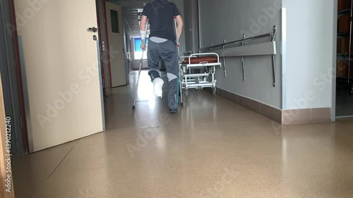 A disabled man with a broken leg uses crutches to walk.
