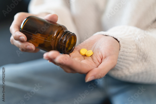 Close-up hands of person holding painkiller pills and water