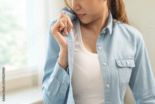 Quadro su tela Smelly clothes laundry, housewife woman having bad smelling clothes on the hand holding breath nose with finger, sniff smelly dirty stinky musty and look disgusting
