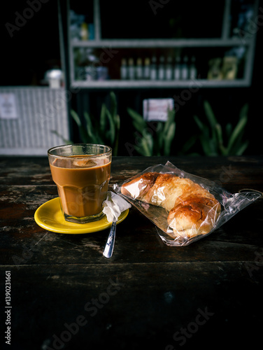 Glass of Coffee with Croissant on Rustic Wooden Table
