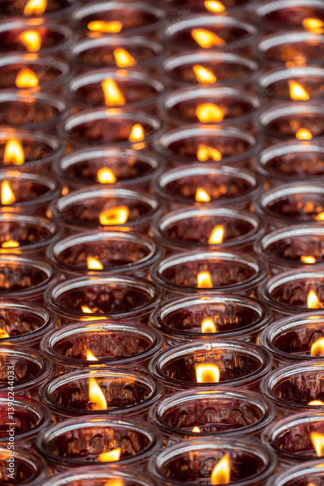 Burning glass of candles in the buddhism temple