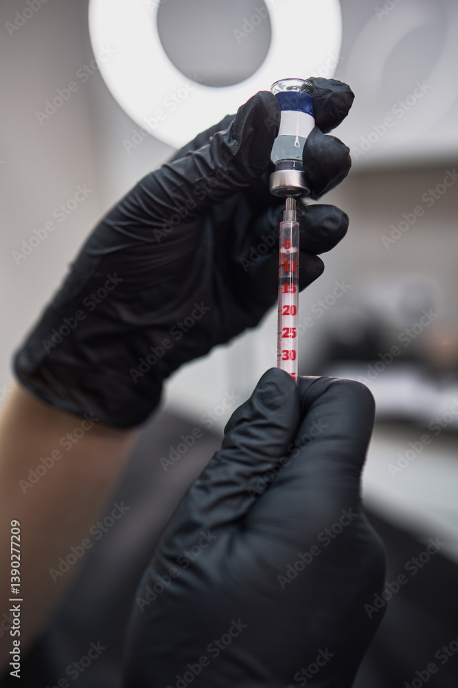 Gloved Hands Holding Syringe with Liquid Medication or Vaccine in Medical Setting Preparation Concept