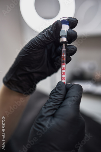Obraz na płótnie Gloved Hands Holding Syringe with Liquid Medication or Vaccine in Medical Setting Preparation Concept w salonie
