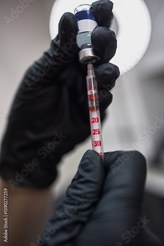 Obraz na płótnie Hands in black gloves holding syringe and vial, precise medical procedure equipment, healthcare concept w salonie