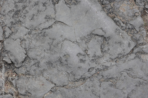 Top Down Close Up View Of A Flat Grey Rock Surface With Natural Cracks And Texture. Abstract Stone Background Or Geology Wallpaper Pattern.