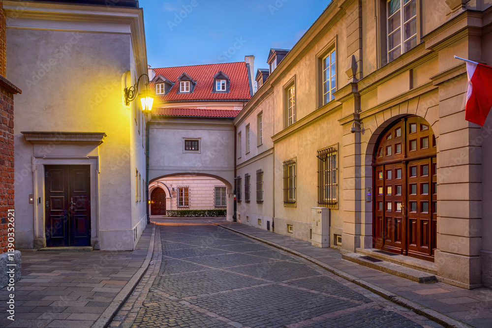 Narrow street with arch at dusk in the Old Town of Warsaw, Poland