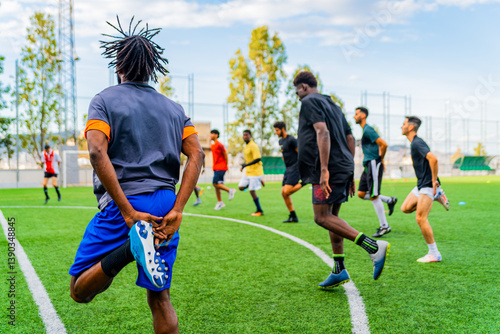 Group of african black young people training in a football pitch and playing football and doing sport. Team of young athletes and coach practicing together in a soccer field