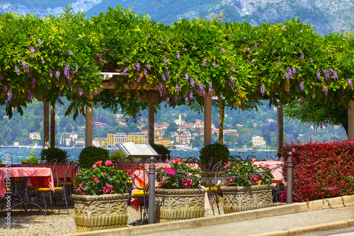 Obraz na płótnie Bellagio, Lombardy, Como Lake, Italy. Famous Italian village and popular European travel destination. Summer scenery, como lake old town landscape mountains. Cosy street restaurant tables view. w salonie