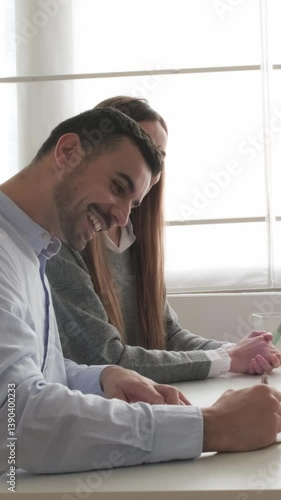 Happy couple signing contract and embracing at office desk