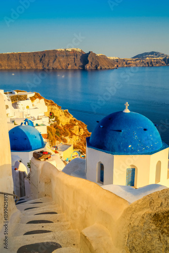 Fototapeta Naklejka Na Ścianę i Meble -  traditional greek village Oia of Santorini, narrow street with blue domes against sea and caldera, Santorini Greece