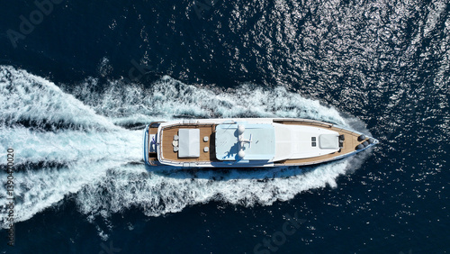 Obraz na płótnie Aerial drone tracking photo of beautiful modern super yacht with wooden deck cruising in low speed deep blue Mediterranean sea w salonie