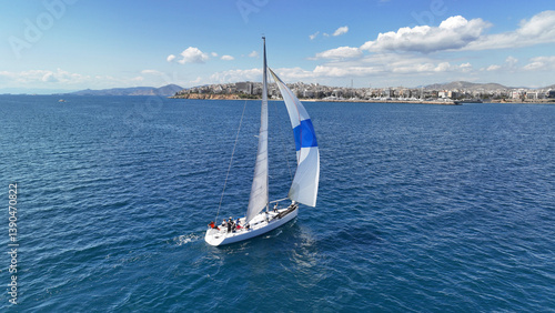 Obraz na płótnie Aerial drone photo of beautiful sail boat with white sails cruising in deep blue sea near port of Piraeus, Attica, Greece w salonie
