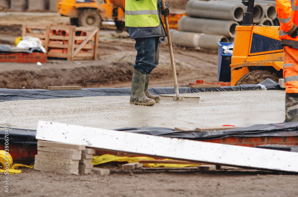 Construction workers pouring concrete on building site Construction workers pouring concrete on building site