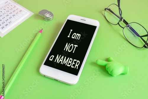I am not a number symbol. Concept words I am not a number written on the mobile phone screen. Beautiful green background. Glasses, coins. Business concept.