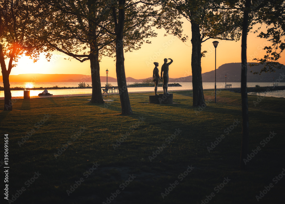 Sunset at Lake Balaton in Fonyód, Hungary with Silhouetted Trees and Statues