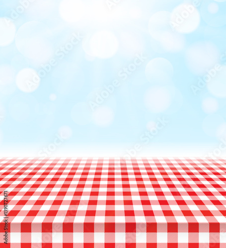 Red checkered tablecloth on sunny picnic background