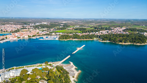 Aerial view of Poreč (Porec), Croatia, showcasing the charming old town, vibrant coastline, and the nearby island of Sveti Nikola. The stunning Zelena Laguna area adds to the beauty turquoise waters
