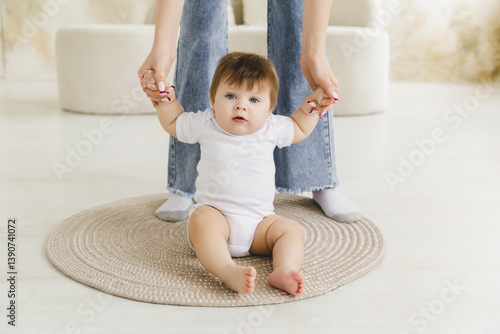 child, childhood and the concept of parenthood - baby learns to walk with mom's help