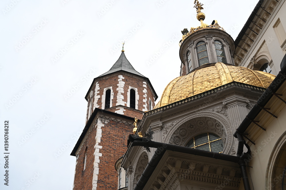 Obraz premium Historic European architecture with golden dome and brick tower. Ornate details of old cathedral facade.