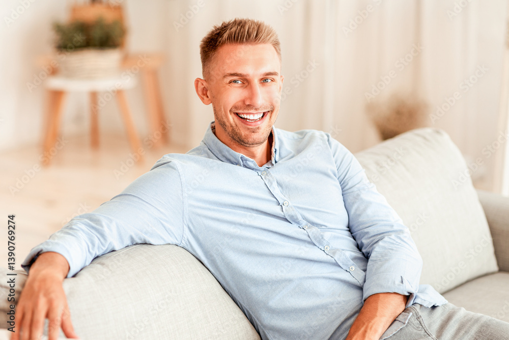 Resting At Home. Portrait Of Cheerful Millennial Guy Sitting And Leaning On Sofa, Looking At Camera, Copy Space Resting At Home. Portrait Of Cheerful Millennial Guy Sitting And Leaning On Sofa, Looking At Camera, Copy Space