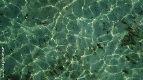The texture of the ocean waves gently reflecting the golden hues of sunset, with soft ripples and a serene, shimmering surface that captures the fading light.