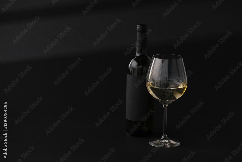 Obraz premium Bottle of wine and wineglass on black background, space for text