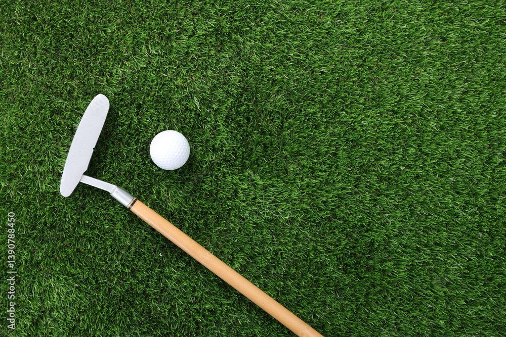 Golf ball and club on green grass, top view. Space for text