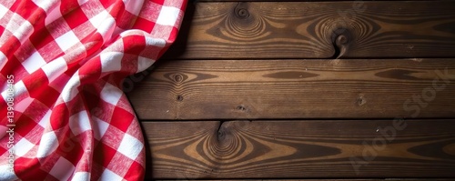 Traditional red and white checkered tablecloth on rustic wooden background, picnic,  summer