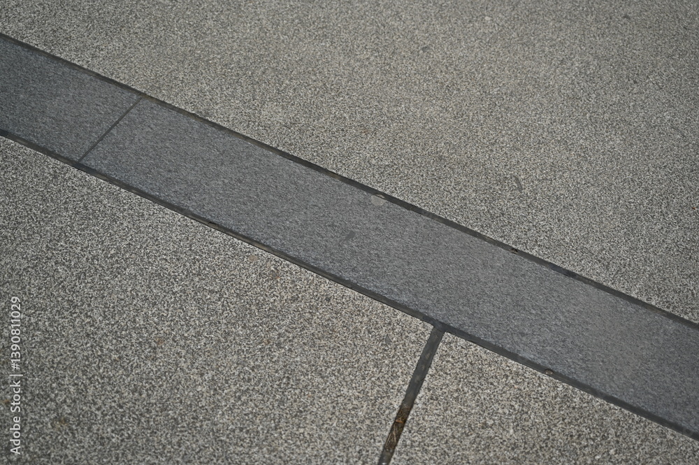 Fototapeta premium Stone pavement with rectangular tiles. Close-up of urban sidewalk surface with textured stone blocks