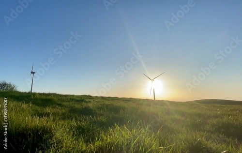Wind turbine slowly spinning during sunset. Captures the contrast between technology and nature, highlighting renewable energy in golden light.