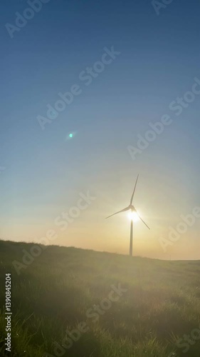 Wind turbine slowly spinning during sunset. Captures the contrast between technology and nature, highlighting renewable energy in golden light.