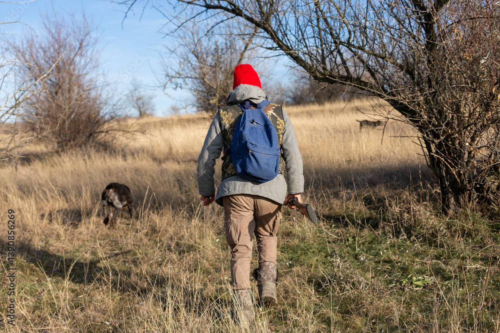 Mature hunter man holding a shotgun and walking through a field Mature hunter man holding a shotgun and walking through a field