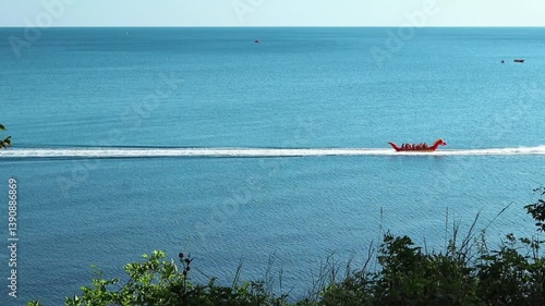 A motor boat carries happy people on an inflatable banana along the Black Sea. Krasnodar region. Vacation, relaxation, entertainment.