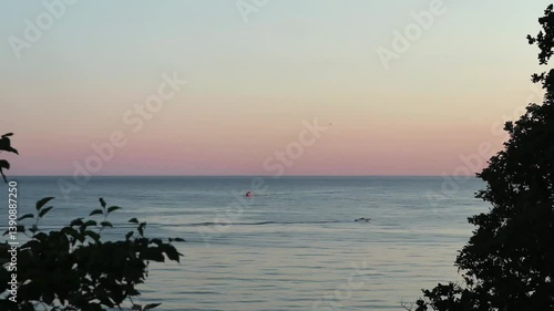 Beautiful, summer, warm sunset on the shores of the Black Sea. Vacation, recreation, tourism. A tourist boat floats in the distance.