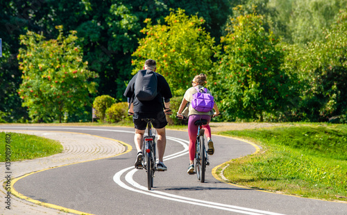 Cyclists ride on the bike path in the city Park