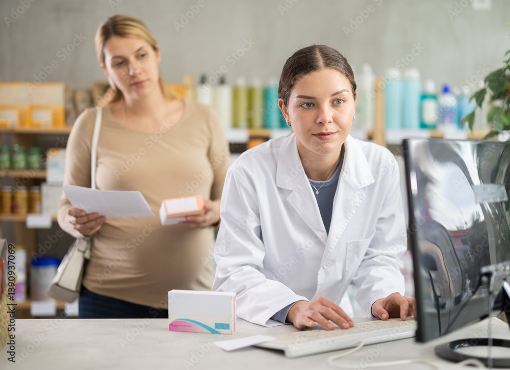 Obraz premium Visiting pharmacy for pregnancy-related supplements, interested pregnant woman holding box of vitamins and prescription while attentive female pharmacist checking product safety for pregnancy use..