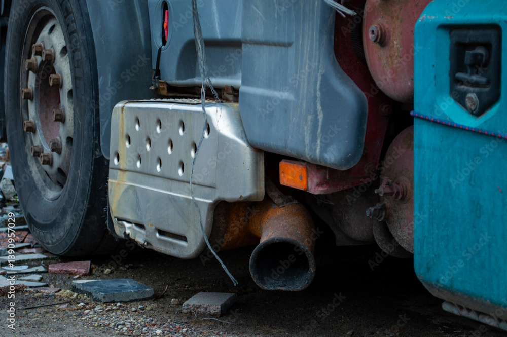 Fototapeta premium A large truck with visible wear parked at a construction site, highlighting its exhaust system in the late afternoon light