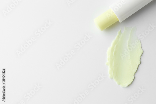 Obraz na płótnie Stick of lip balm and sample on white background, top view. Space for text w salonie