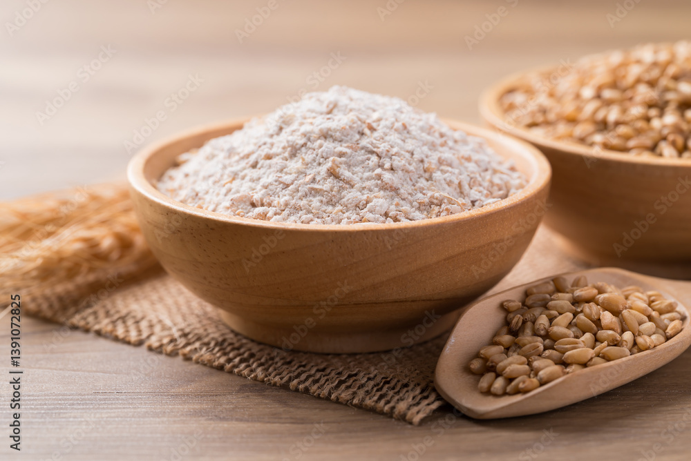 Whole wheat flour with wheat grain in bowl on wooden background Whole wheat flour with wheat grain in bowl on wooden background