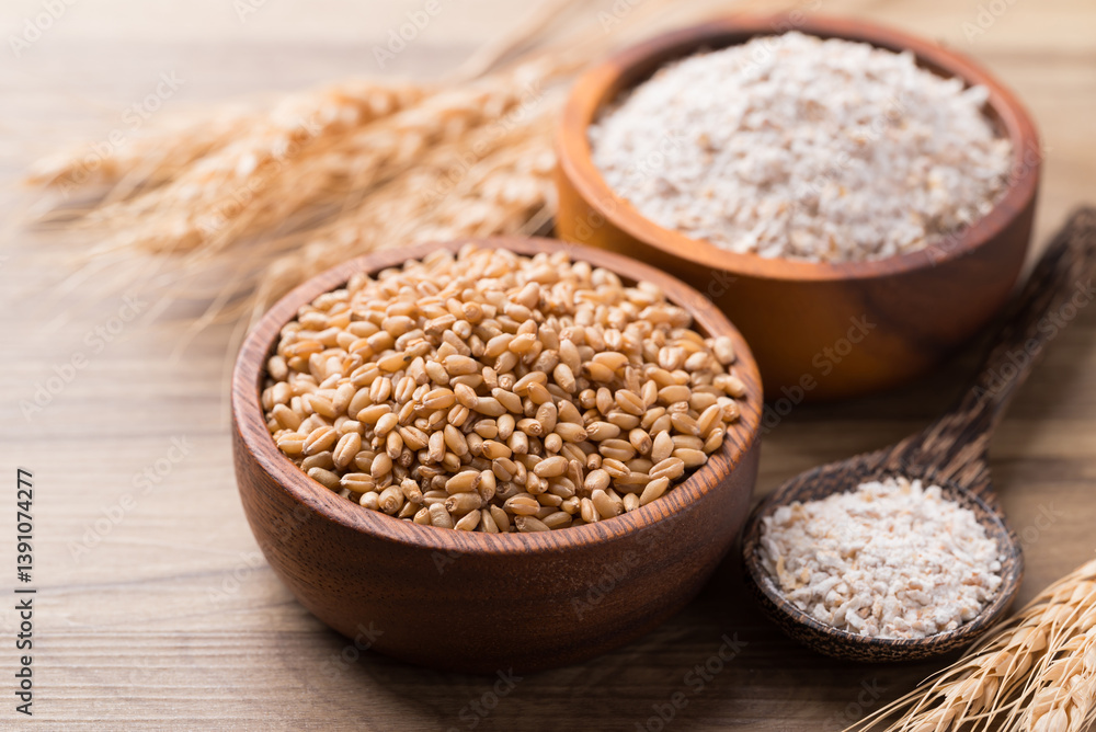 Wheat grain and whole wheat flour in bowl on wooden background Wheat grain and whole wheat flour in bowl on wooden background